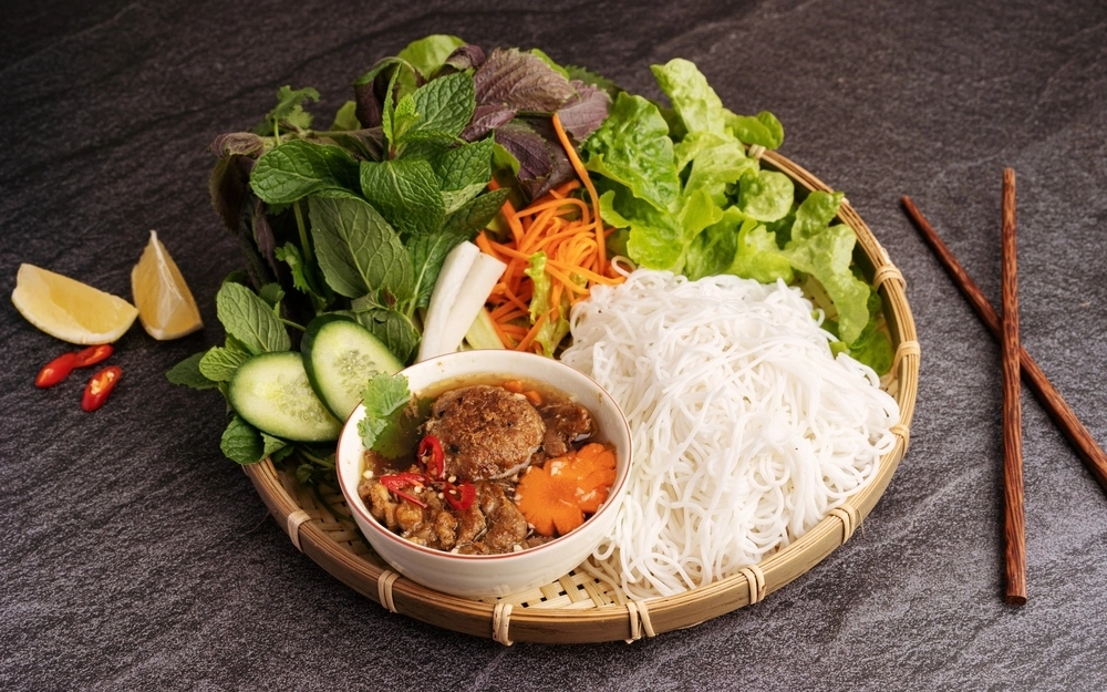 Bun cha in Hanoi with grilled pork, rice noodles, herbs, and dipping sauce
